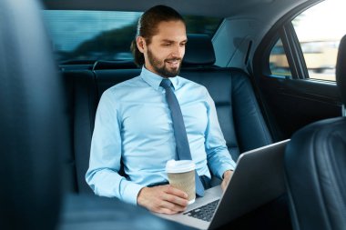 Arabada kahve içme ve defter üzerinde çalışma adam.