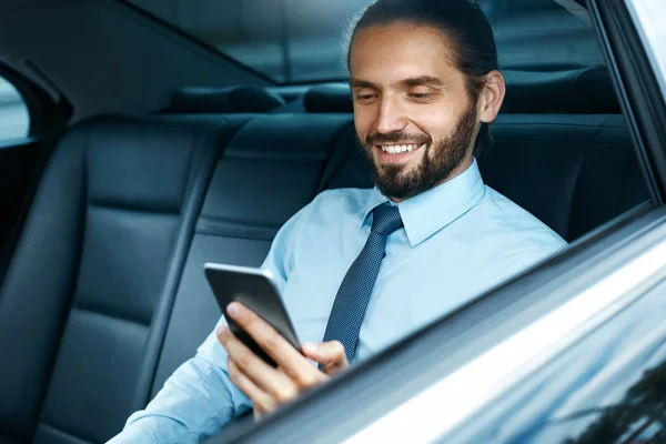 Giovane uomo di successo che lavora al telefono seduto in auto . — Foto Stock