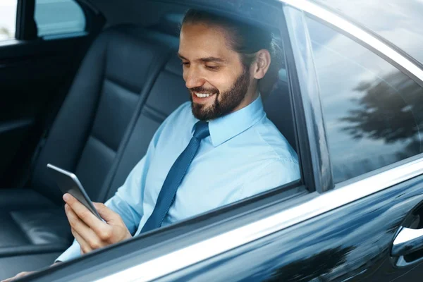 Jovem homem de sucesso trabalhando no telefone sentado no carro . — Fotografia de Stock