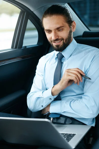 Retrato del hombre de negocios trabajando en cuaderno, viajando en coche . — Foto de Stock