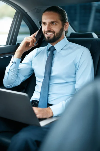 Деловой человек в машине звонит по телефону во время поездки на работу — стоковое фото