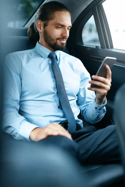 Jovem homem de sucesso trabalhando no telefone sentado no carro . — Fotografia de Stock