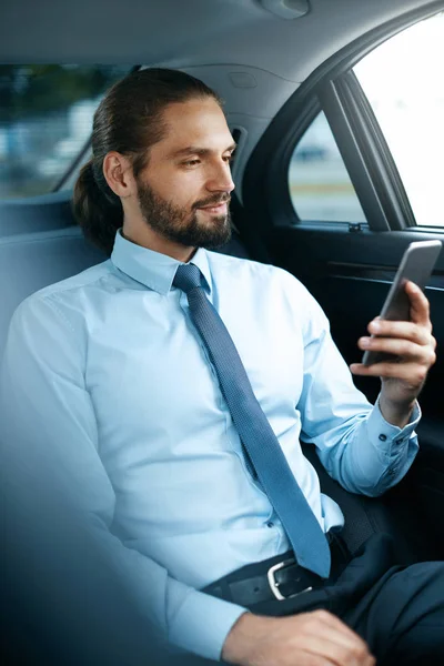 Jovem homem de sucesso trabalhando no telefone sentado no carro . — Fotografia de Stock