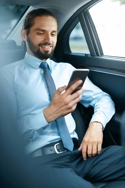 Jonge succesvolle Man bezig met telefoon zitten In auto. — Stockfoto