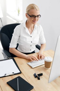 İş adamları. Ofiste bilgisayar üzerinde çalışan kadın