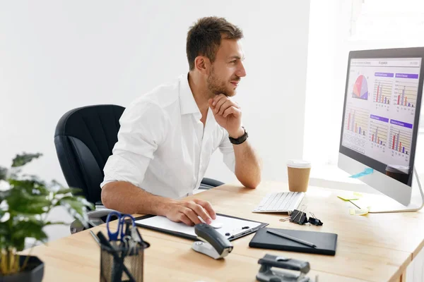 Joven hombre de negocios trabajando en la computadora en la oficina . — Foto de Stock