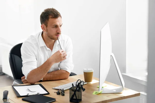 Jeune homme d'affaires travaillant sur l'ordinateur au bureau . — Photo