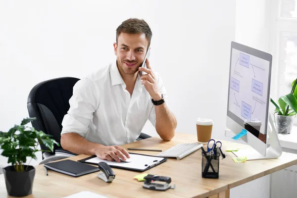 Бизнесмен разговаривает по телефону на рабочем месте — стоковое фото