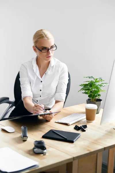 Mulher de trabalho tomando notas no escritório — Fotografia de Stock