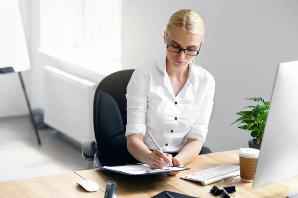 Berufstätige Frau macht sich Notizen im Büro — Stockfoto