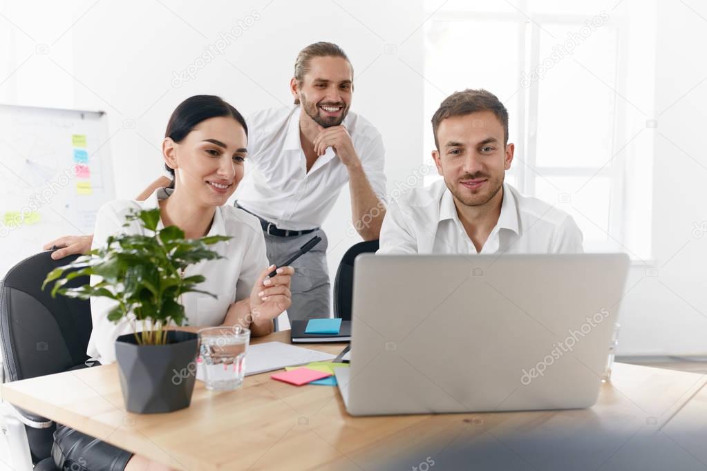 Team Working In Office, Looking At Computer