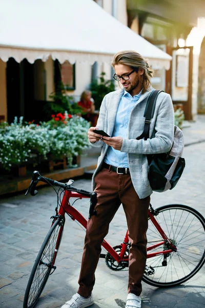 Man With Bicycle Using Phone On Street.