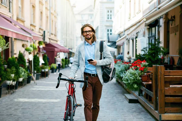 Man With Bicycle Using Phone On Street.