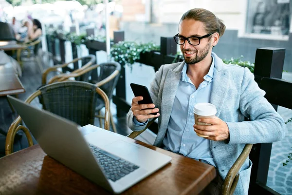 Homem com telefone bebendo café no café — Fotografia de Stock