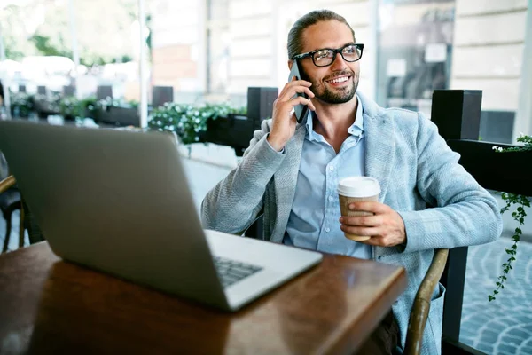 Praca z Cafe. Mężczyzna rozmawia telefon pracuje w Cafe — Zdjęcie stockowe