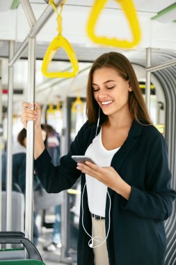 Genç güzel kadın otobüs telefon müzik dinleme.