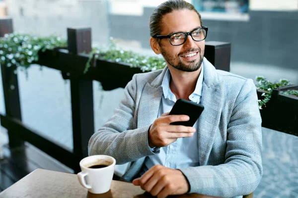 Homem com telefone bebendo café no café — Fotografia de Stock