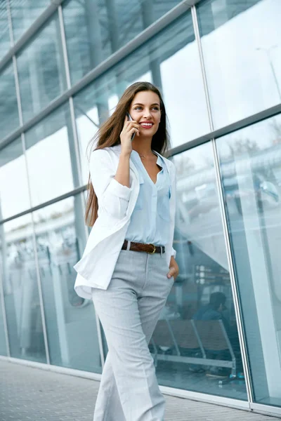 Professionele vrouw praten over de telefoon tijdens een wandeling rond de straat. — Stockfoto