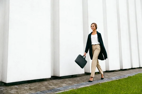 Портрет стильной деловой женщины с сумочкой в руке на открытом воздухе — стоковое фото
