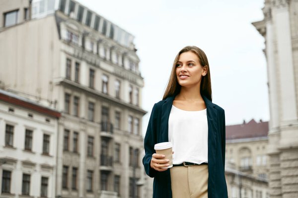 "Деловая женщина с напитком" на прогулке по улице
.