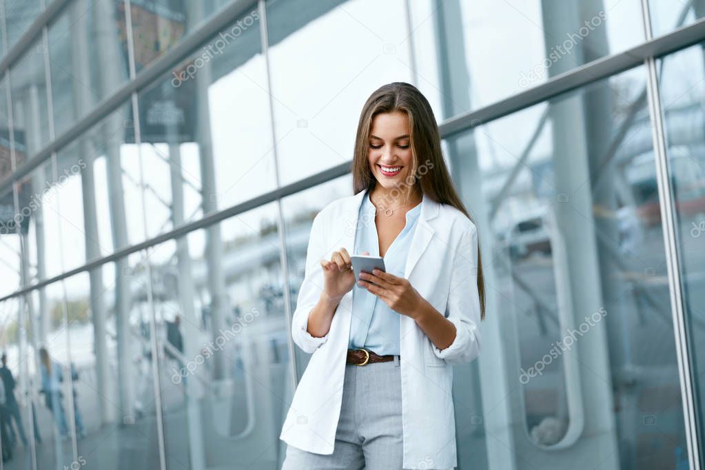 Portrait Of Smiling Business Woman With Phone On Street.