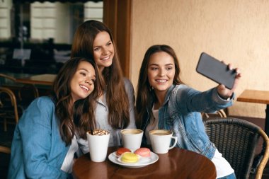 Selfie fotoğrafta telefonla Cafe güzel kızlar.