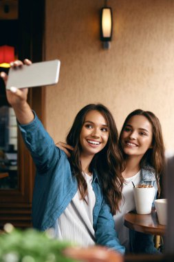 Cafe toplantı kadınlar. Telefonda fotoğrafta arkadaşlar.