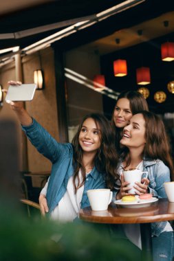 Cafe toplantı kadınlar. Telefonda fotoğrafta arkadaşlar.