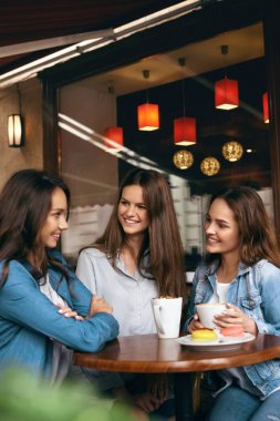 Cafe kadınlar. Güzel kızlar bardak kahve ile konuşmak.
