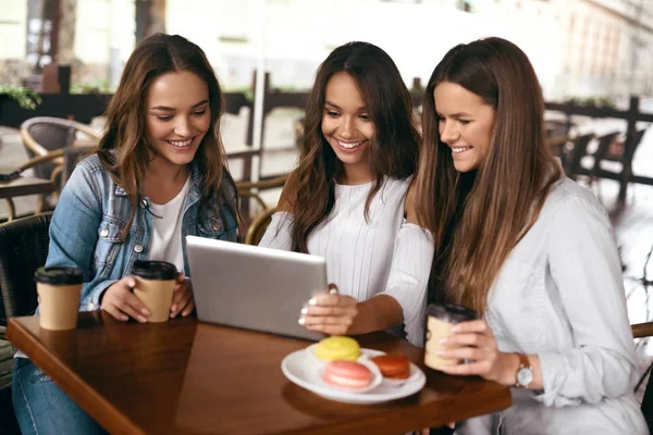 Amigos en Café. Hermosas chicas sonrientes usando tableta . — Foto de Stock