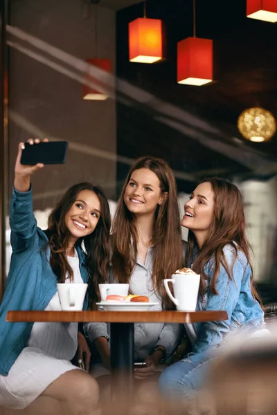 Όμορφα κορίτσια στο Cafe λήψη Selfie φωτογραφία στο τηλέφωνό. — Φωτογραφία Αρχείου