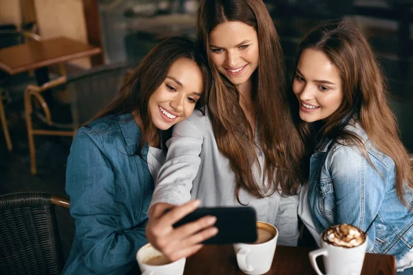 Freunde amüsieren sich, fotografieren im Café. — Stockfoto