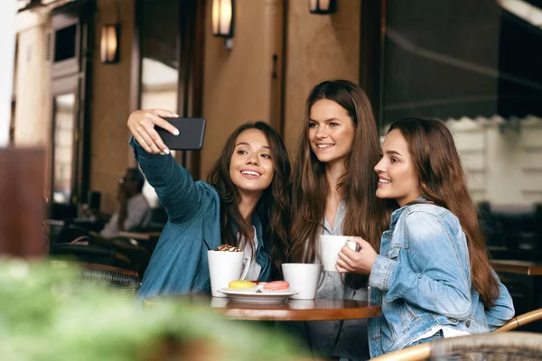 Freunde amüsieren sich, fotografieren im Café. — Stockfoto