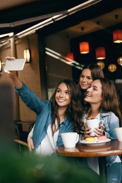 Frauen treffen sich im Café. Freunde fotografieren am Telefon. — Stockfoto