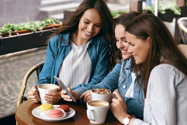 Mujeres felices usando el teléfono en el café . — Foto de Stock