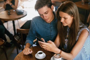 Mutlu çift telefon, Cafe oturan kullanarak.