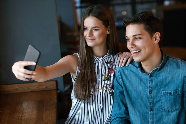 Paar im Café. junges Paar fotografiert am Telefon. — Stockfoto