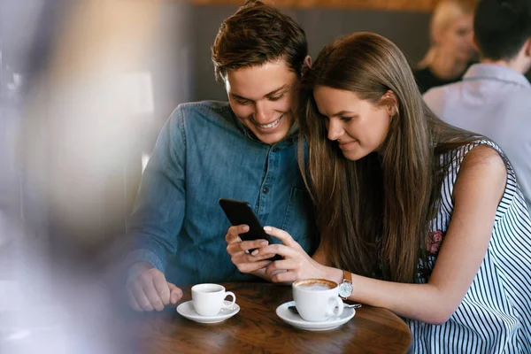 Coppia felice utilizzando il telefono, seduto nel caffè . — Foto Stock