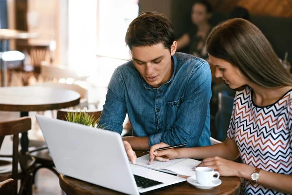 Jeune couple étudiant, utilisant l'ordinateur dans le café . — Photo