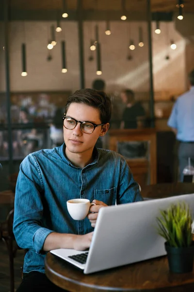 Człowiek pije kawę i pracy na notebooku w Cafe. — Zdjęcie stockowe