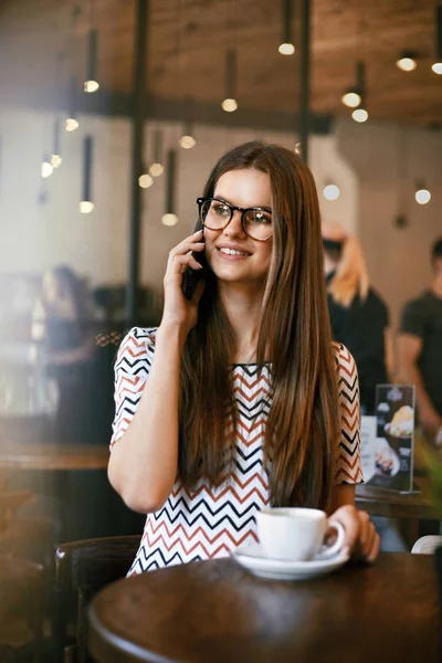 Mujer en Café. Mujer hablando por teléfono mientras bebe café . — Foto de Stock