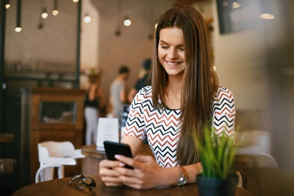 Mulher bonita com telefone no café . — Fotografia de Stock