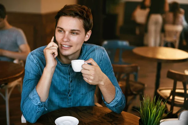 Hombre hablando por teléfono y bebiendo café en el café . — Foto de Stock