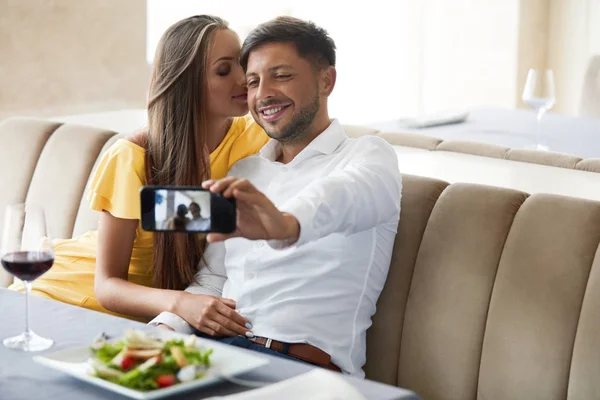 Para w restauracji. Para, robienia zdjęć na telefon. — Zdjęcie stockowe