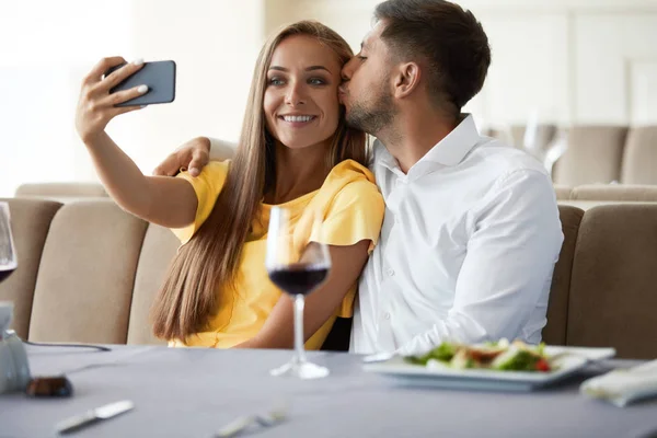 レストランのカップル。携帯電話で写真を撮るカップル. — ストック写真