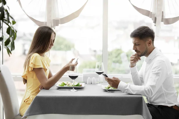 Problema de comunicação. Homem e mulher com telefones em data — Fotografia de Stock