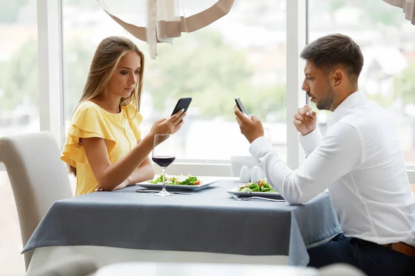 Problème de communication. Homme et femme avec des téléphones sur la date — Photo