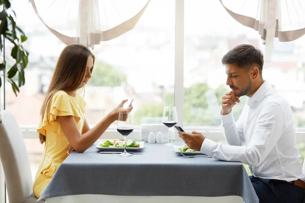 Communication Problem. Man And Woman With Phones On Date — Stock Photo, Image