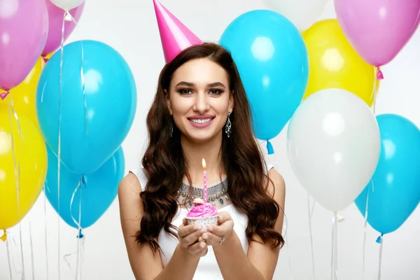 З днем народження. Дівчина з повітряними кулями і торт на вечірці — стокове фото