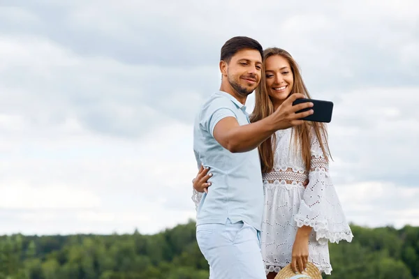 Romântico. Casal feliz no amor tirar fotos no telefone na natureza — Fotografia de Stock